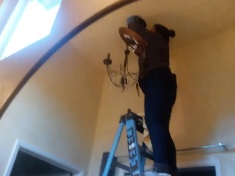 Electrician installing a chandelier in a Lake St. Louis residence